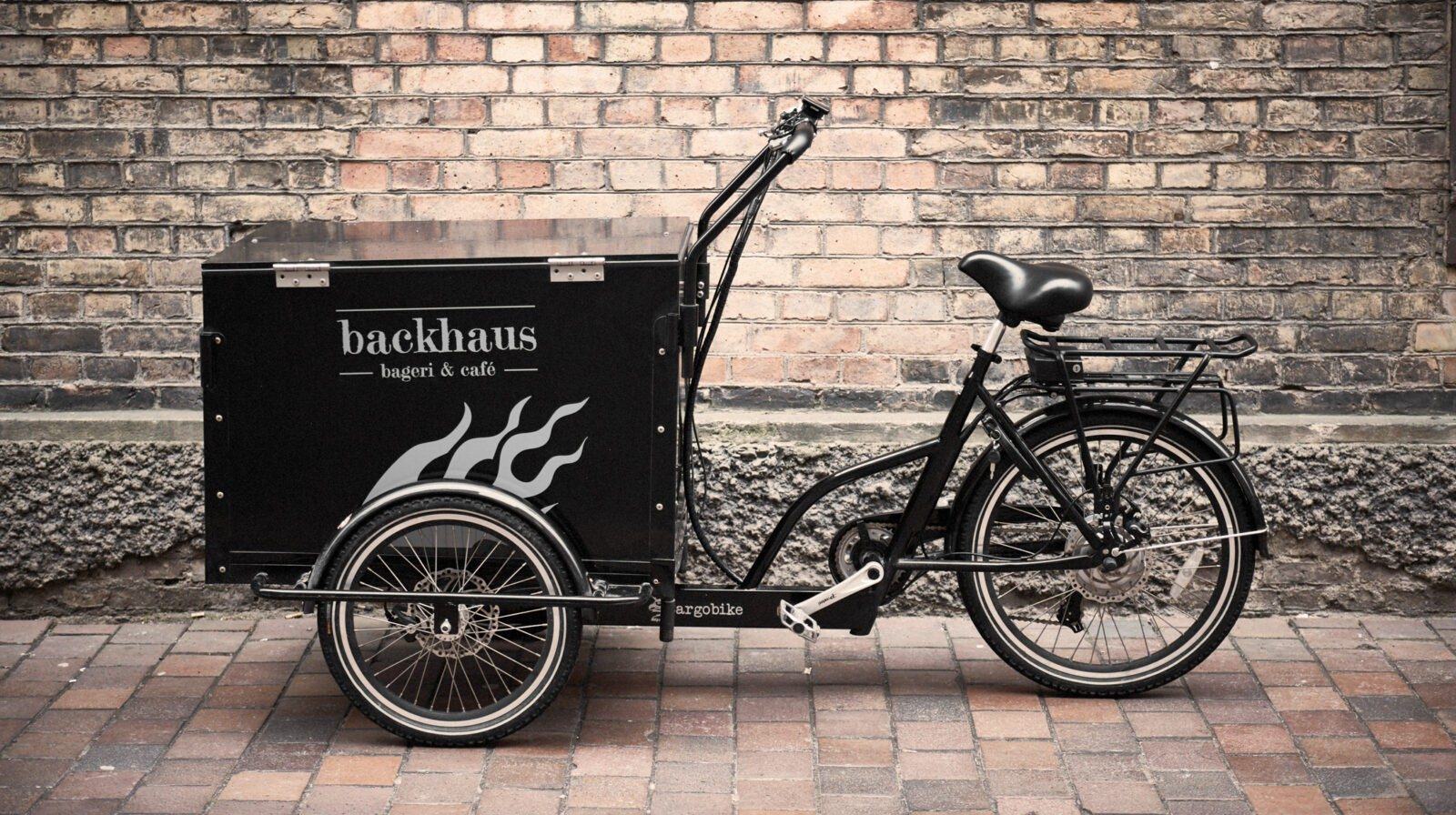 Backhaus lastcykel framför en tegelvägg